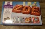 Wilton Countless Celebrations Cake Pan Numbers Letters Set New, Open Box. Fixed Price $19.00.